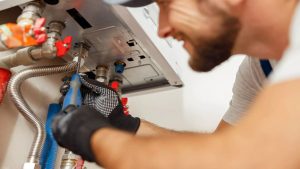 closeup-of-plumber-using-screwdriver-while-install