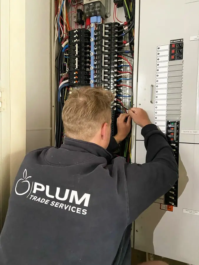 Electrician carrying out preventative maintenance on a commercial switchboard