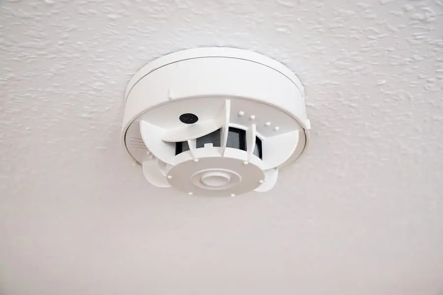 Hard-wired smoke detector installed on a ceiling